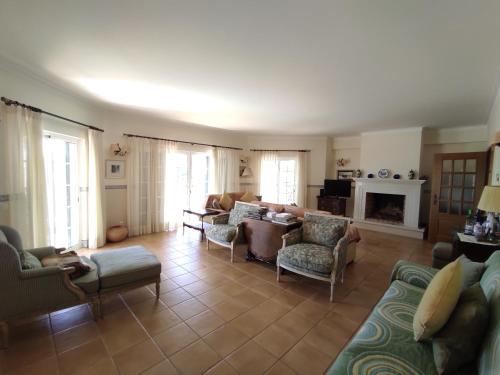 a living room with couches and chairs and a fireplace at Sweet Home Lux Villa Vau in Portimão