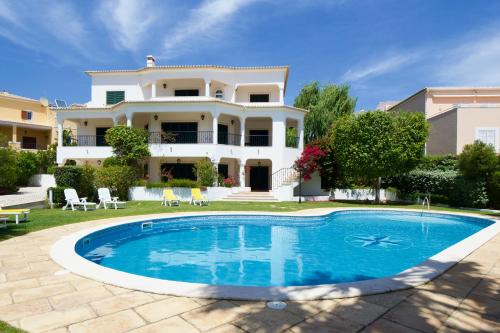 a villa with a swimming pool in front of a house at Sweet Home Lux Villa Vau in Portimão