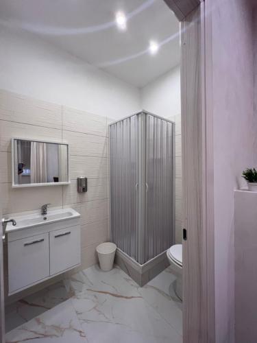 a white bathroom with a toilet and a sink at Easy Boarding in Naples