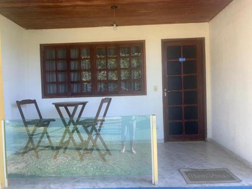a glass table and chairs in front of a house at Hotel Fazenda VCP in Silva Jardim
