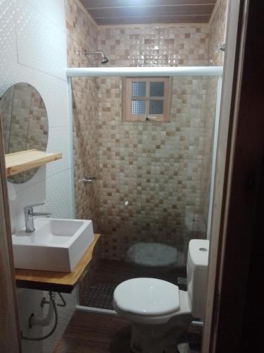 a bathroom with a sink and a toilet and a shower at cabanas paisagem da serra in Urubici