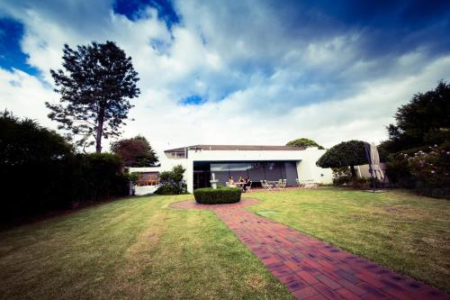 a building with a brick path in front of a yard at Sandown Regency Hotel & Apartments in Noble Park