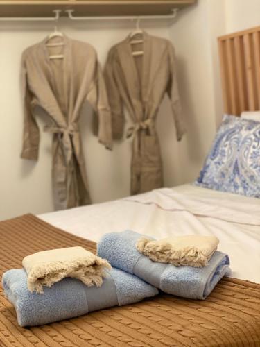 een bed met handdoeken en kleding aan een muur bij Villa Christina in Ohrid