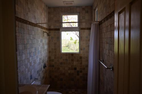 a bathroom with a window and a sink and a toilet at Casa Tanamera in Boca Chica
