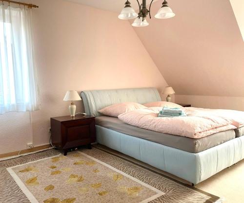 1 dormitorio con 1 cama y 1 mesa con lámpara en Doppelhaushälfte nahe Flughafen Hamburg, en Norderstedt