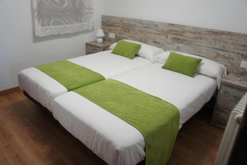 sypialnia z 2 łóżkami i zielonymi poduszkami w obiekcie Mirador de San Marcos w mieście Soria