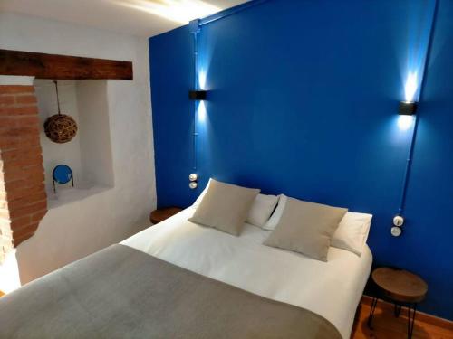 um quarto azul com uma cama branca e uma parede azul em Bonito y céntrico apartamento casco antiguo em Tarragona