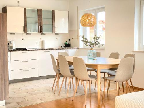 a kitchen with a wooden table and chairs at RONI APARTMENTS -111qm Luxury Loft -Near Center and Clinics -Netflix -Terrace -Close to Thermal Spa in Bad Aibling