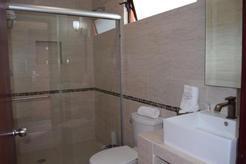 a bathroom with a shower and a toilet and a sink at Hotel Chapala Country in Chapala