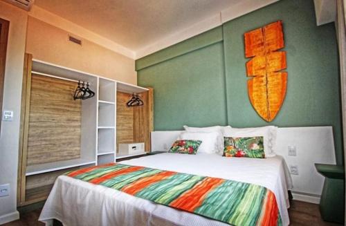 a bedroom with a bed with a surfboard on the wall at HotBeachSuites Lazer e Diversão in Olímpia