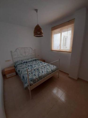a small bedroom with a bed and a window at Apartamento en el Grao de Gandía in Gandía