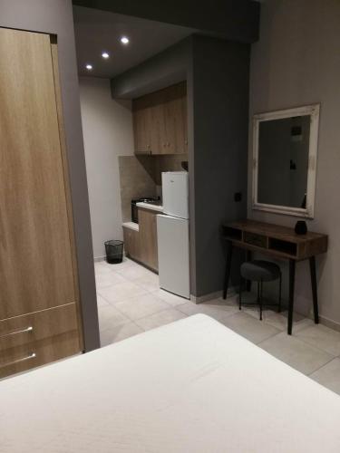 a room with a kitchen with a desk and a refrigerator at doloras_methana in Methana