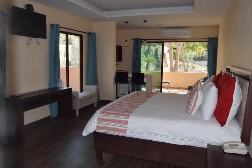 een slaapkamer met een bed, een bureau en een televisie bij Hotel Chapala Country in Chapala