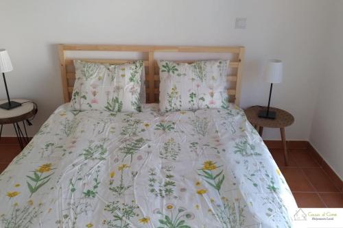 a bed with a white comforter and two lamps at Casa D'Avó (1º Andar) in Altura