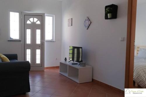 a living room with a bed and a television on a table at Casa D'Avó (1º Andar) in Altura