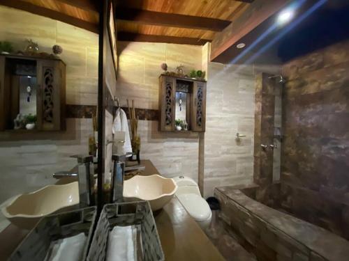 Finca exclusiva cerca a la reserva El Romeral في La Estrella: حمام به مغسلتين وحوض استحمام