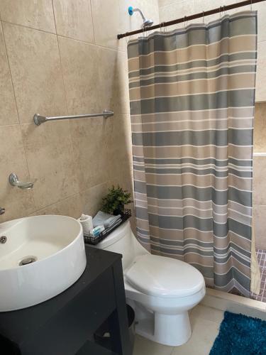 a bathroom with a toilet and a shower curtain at Beautiful house at Rosarito beach in San Antonio del Mar