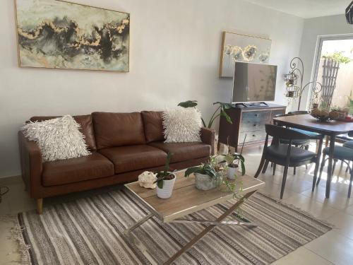 uma sala de estar com um sofá castanho e uma mesa em Beautiful house at Rosarito beach em San Antonio del Mar