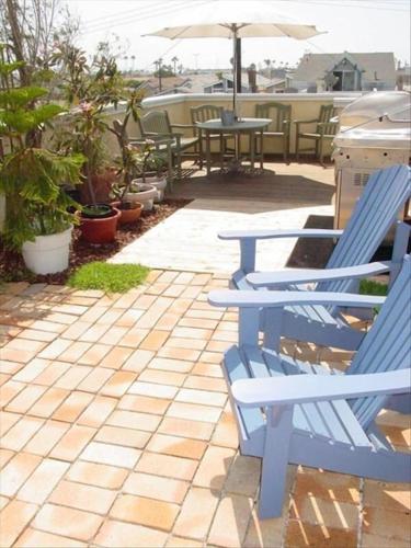 two blue chairs and an umbrella on a patio at the Newport Family Peninsula Beach House in Newport Beach