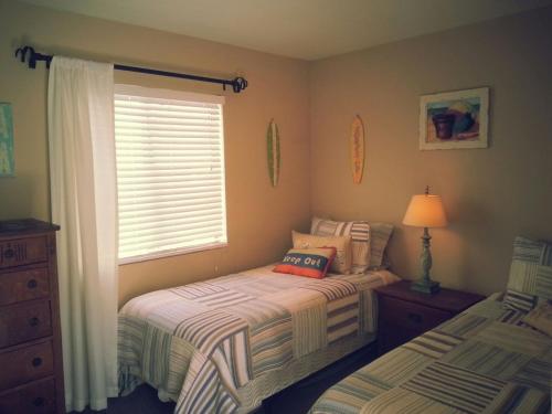 a bedroom with two twin beds and a window at the Newport Family Peninsula Beach House in Newport Beach