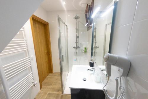 y baño con ducha, lavabo y espejo. en Cal Planell Casa Rural, en Vall-Llebrera