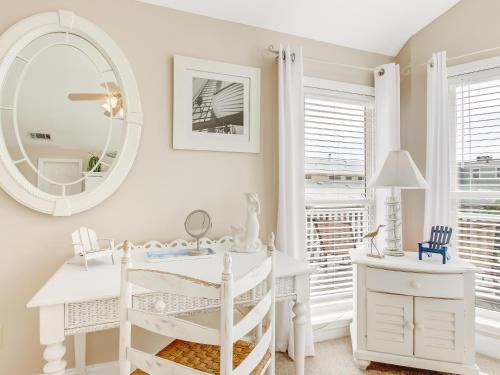 een witte kamer met een spiegel en een wit bureau bij Almost Heaven in Tybee Island