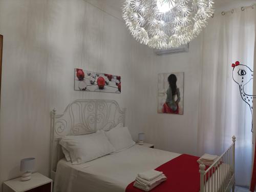 a bedroom with a bed and a chandelier at B&B Il Siciliano in Syracuse