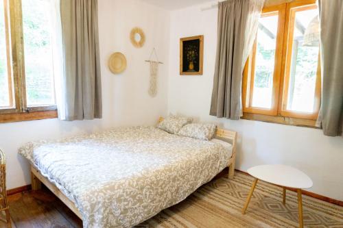 AleChatki Roztocze في Huta Lubycka: غرفة نوم مع سرير في غرفة مع نوافذ