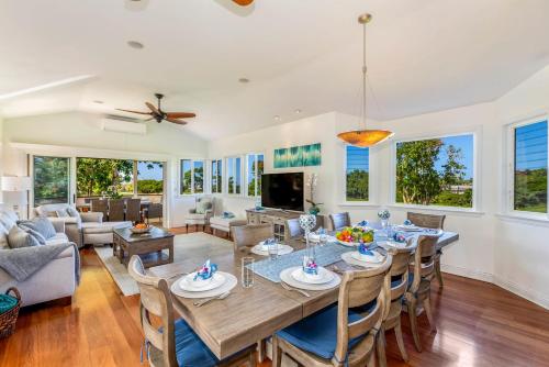 a dining room and living room with a table and chairs at Ohana Kamalani in Princeville