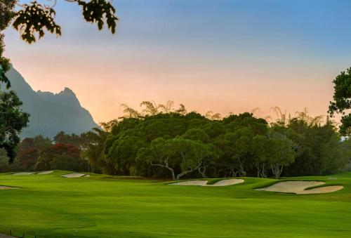 a view of a golf course with trees at Ohana Kamalani in Princeville