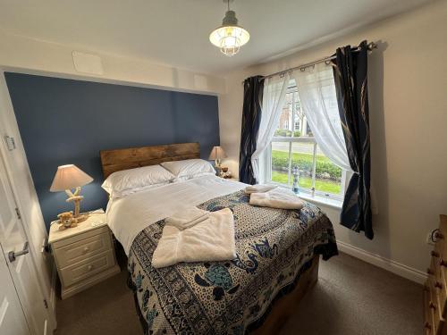 Un dormitorio con una cama grande y una ventana en Seascape Apartment, en Filey