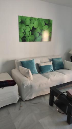 ein Wohnzimmer mit einem weißen Sofa und einem Tisch in der Unterkunft Casa Trebol Parquing Gratis in Estepona