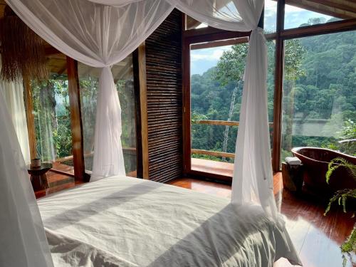 a bedroom with a bed and a large window at Wild Wasi Lodge - Adventures - Guided Tours in Puyo