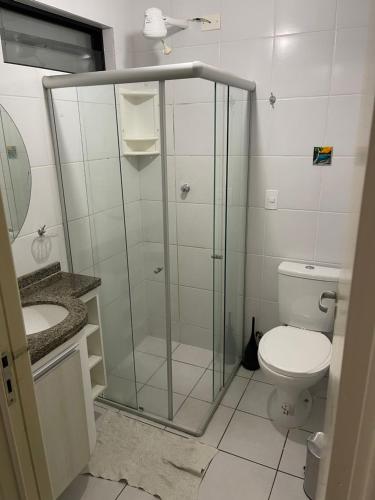 uma casa de banho com uma cabina de duche em vidro e um WC. em Apartamento Jatiuca em Maceió