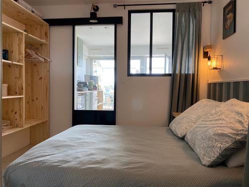 1 dormitorio con cama y ventana en Les reflets de l'étang, en Balaruc-les-Bains
