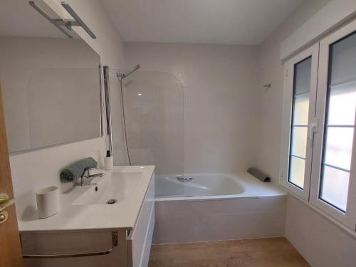ein weißes Badezimmer mit einer Badewanne und einem Waschbecken in der Unterkunft ARODRI SELLA in Ribadesella