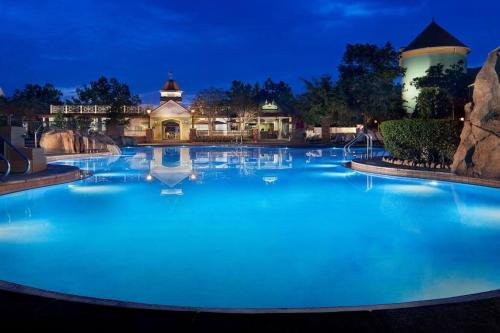 a large pool with blue water at night at Disney's Saratoga Springs Resort and Spa in Orlando