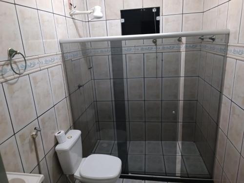 a small bathroom with a toilet and a shower at Casa Temporada Prado-BA in Prado