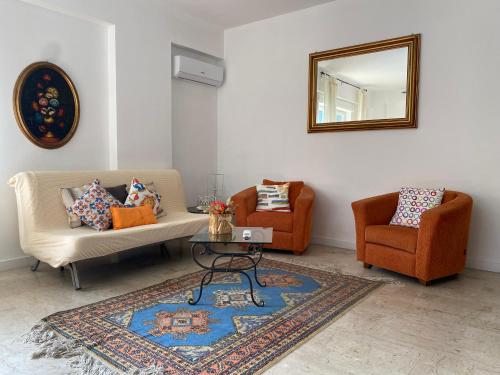 a living room with two couches and a table and a mirror at relax home in Marsala