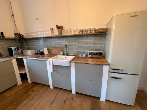 a kitchen with a sink and a refrigerator at Ferienwohnung Hortensie Rittergut Schloss Zehista Gutshaus in Pirna