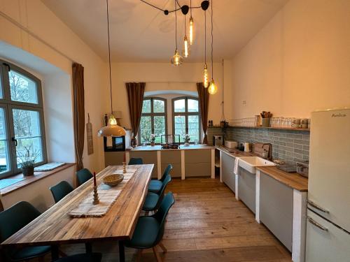 a large kitchen with a wooden table and chairs at Ferienwohnung Hortensie Rittergut Schloss Zehista Gutshaus in Pirna