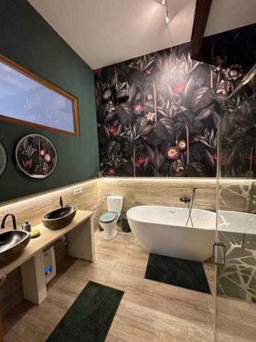 a bathroom with a large tub and a painting on the wall at Ferienwohnung Hortensie Rittergut Schloss Zehista Gutshaus in Pirna