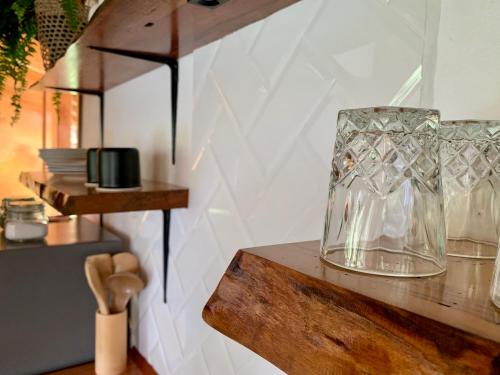 プヨにあるWild Wasi Lodge - Adventures - Guided Toursの木棚に座る一群のガラス花瓶