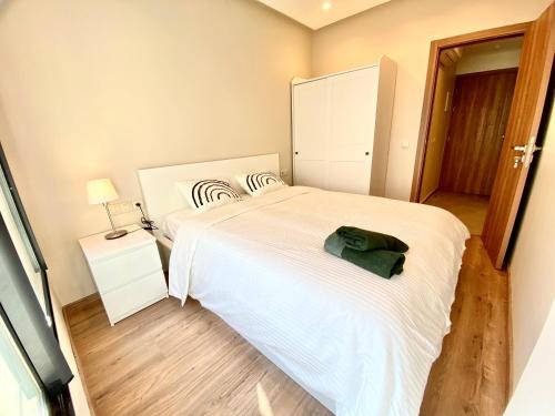 a bedroom with a white bed with a green bag on it at Appartement cosy à proximité immédiate du célèbre Twins-center in Casablanca