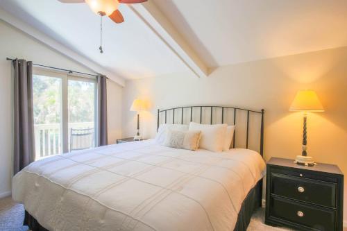 a bedroom with a large bed and a window at Oak Woods Cottage in Kiawah Island
