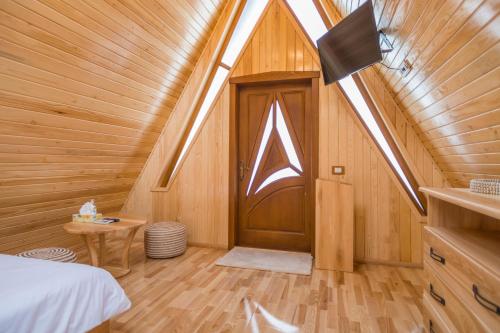 ein Zimmer mit einer Tür in einem Holzhaus in der Unterkunft Arhico Cabins in Satu Mare