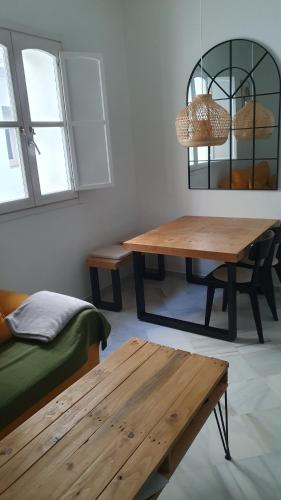 a room with two tables and a couch and a mirror at apartamento gaditano in Cádiz