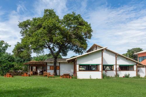 una casa con un árbol en el patio en Pousada Real Cipo, en Serra do Cipo