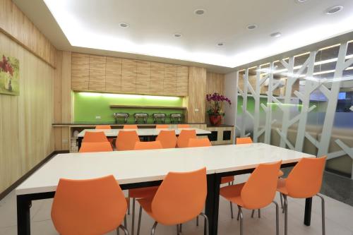 a conference room with a table and orange chairs at Guo Chen Hotel in Luodong