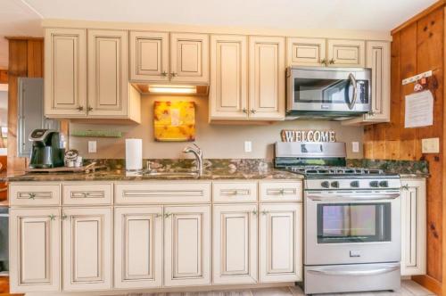 Sagamore Beachにある300 Phillips Road Sagamore Beach - Cape Codのキッチン(白いキャビネット、コンロ、電子レンジ付)
